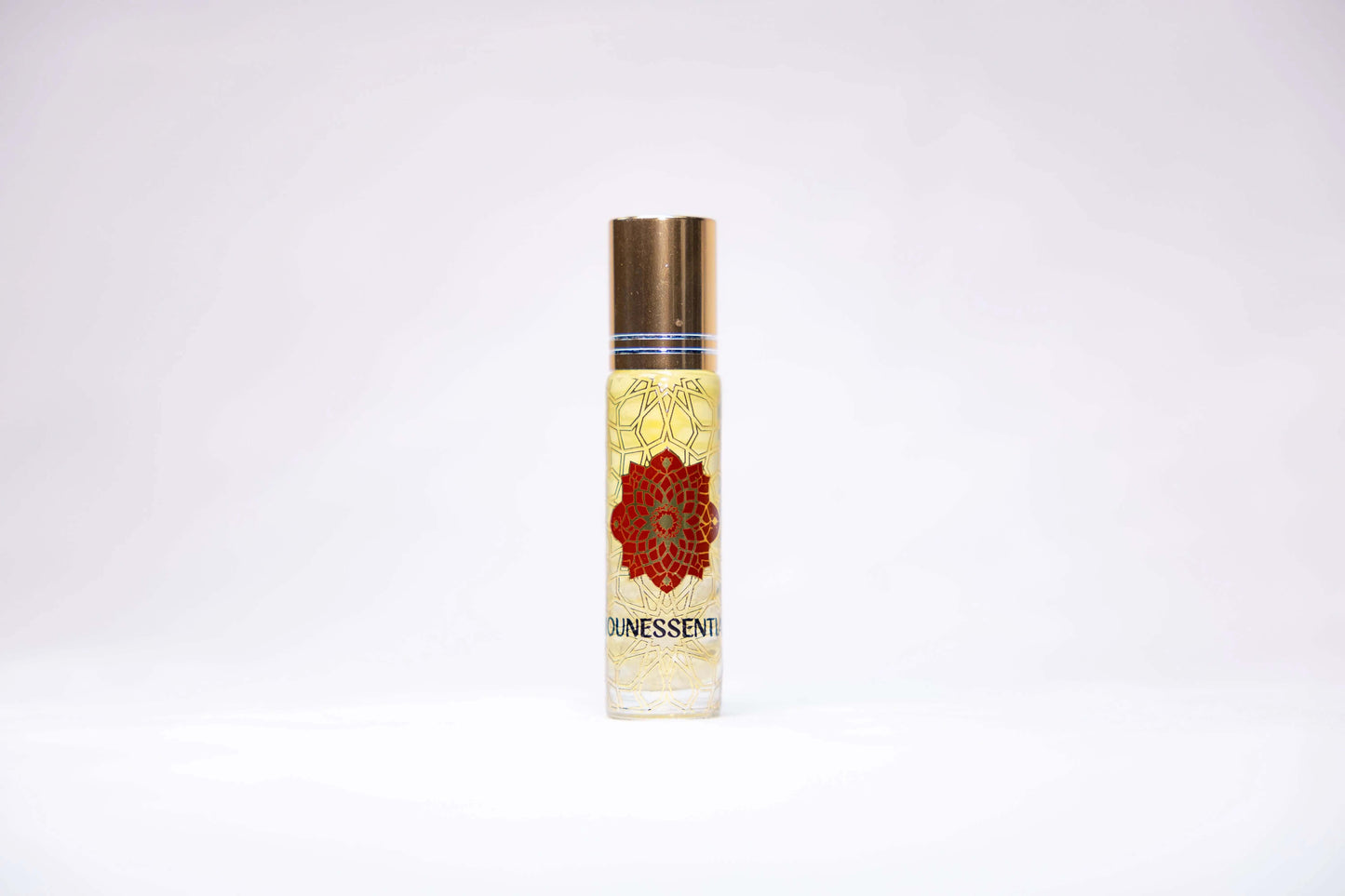 Amber & Clear Quartz Infusion Roll-On: gold-capped glass rollerball with red floral design and golden liquid