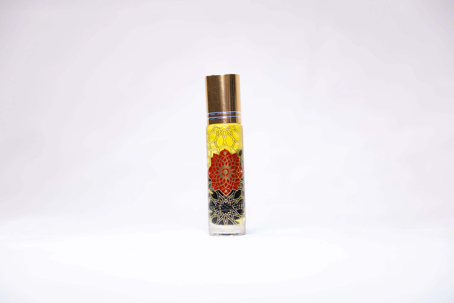 Cinnamon and Garnet Infusion Roll-On perfume bottle with gold cap and floral designs