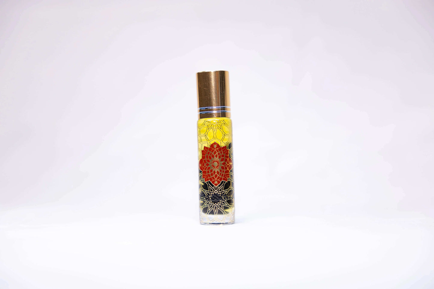 Cinnamon and Garnet Infusion Roll-On perfume bottle with gold cap and floral designs
