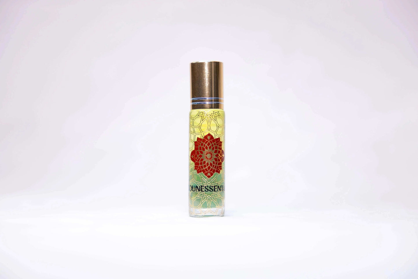 Clear glass roll-on perfume bottle with gold cap, red mandala label, Ounessenti brand, peridot-infused eucalyptus scent