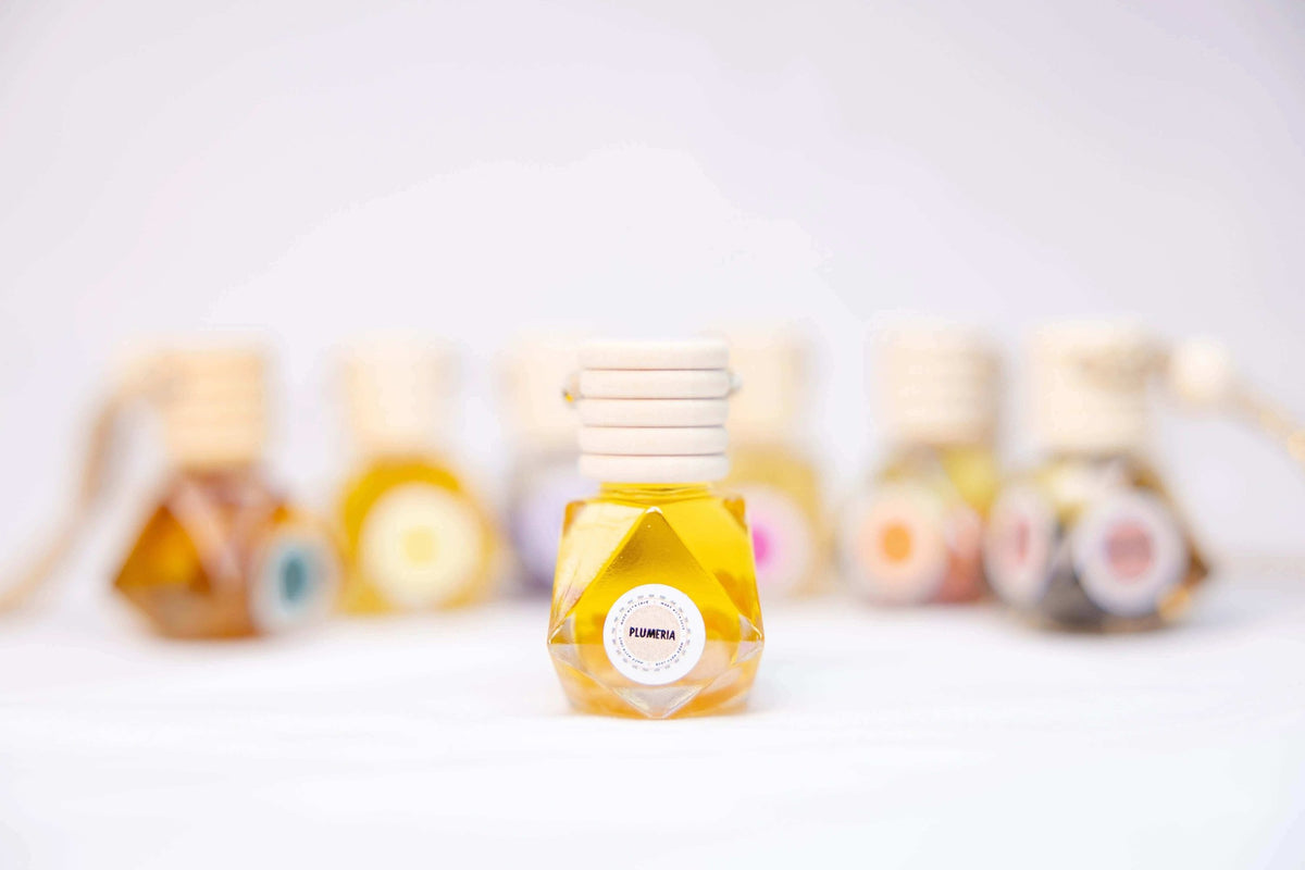 Clear faceted glass bottle of golden essential oil for car diffuser